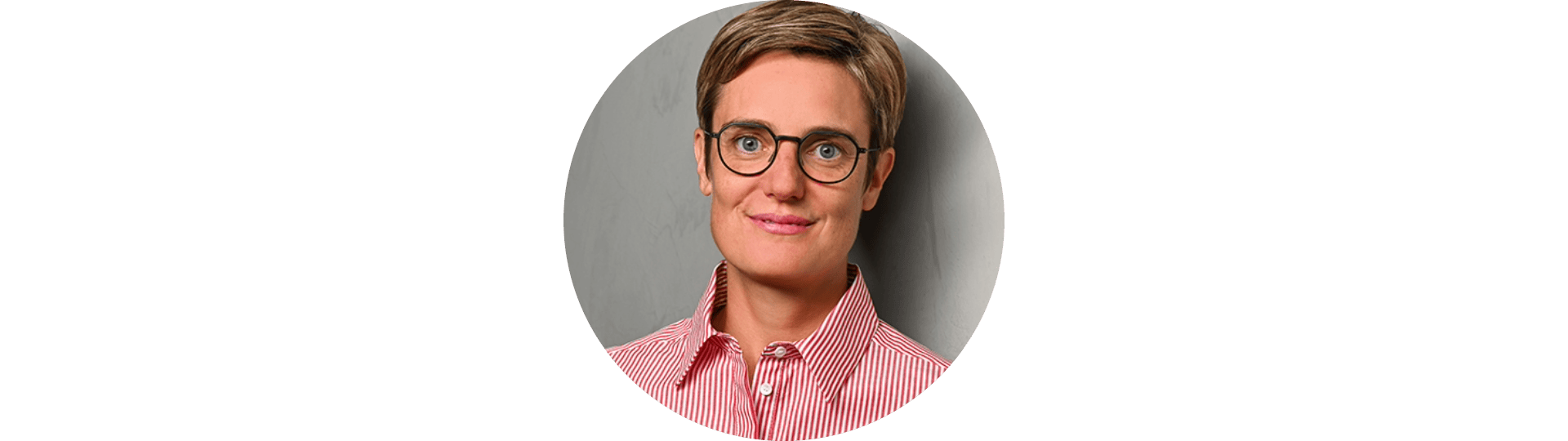 Die Autorin des Newsletters Nina Schick steht vor einem grauen Hintergrund.