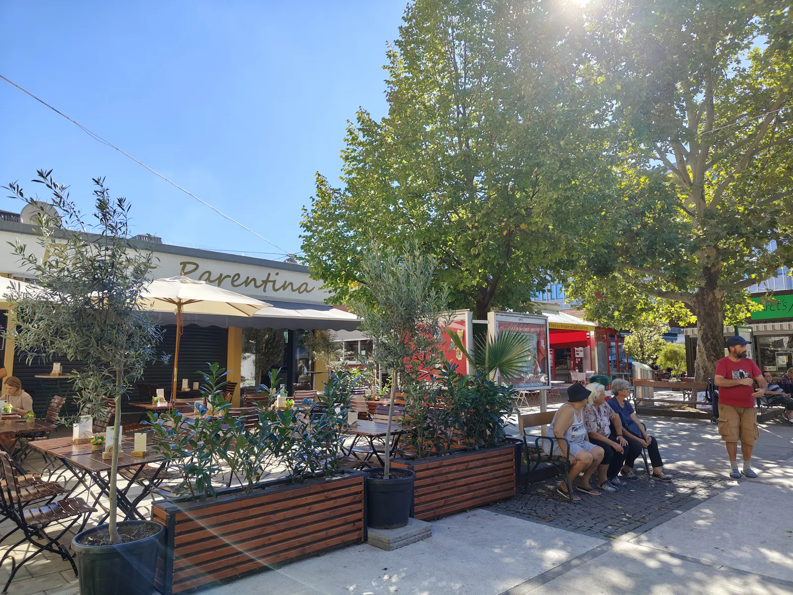 Open-air seating, gastronomy and market life under leafy trees at Meidlinger Markt | Meidlinger Markt Stand 21-22, 1120 Wien