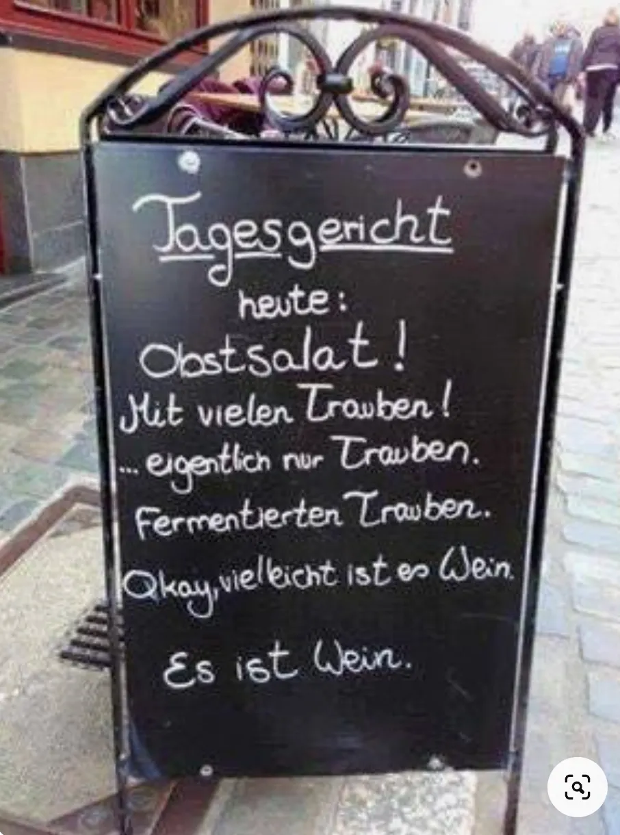 Schild: »Tagesgericht heute: Obstsalat! Mit vielen Trauben! ... eigentlich nur Trauben. Fermentierten Trauben. Okay, vielleicht ist es Wein. Es ist Wein.«