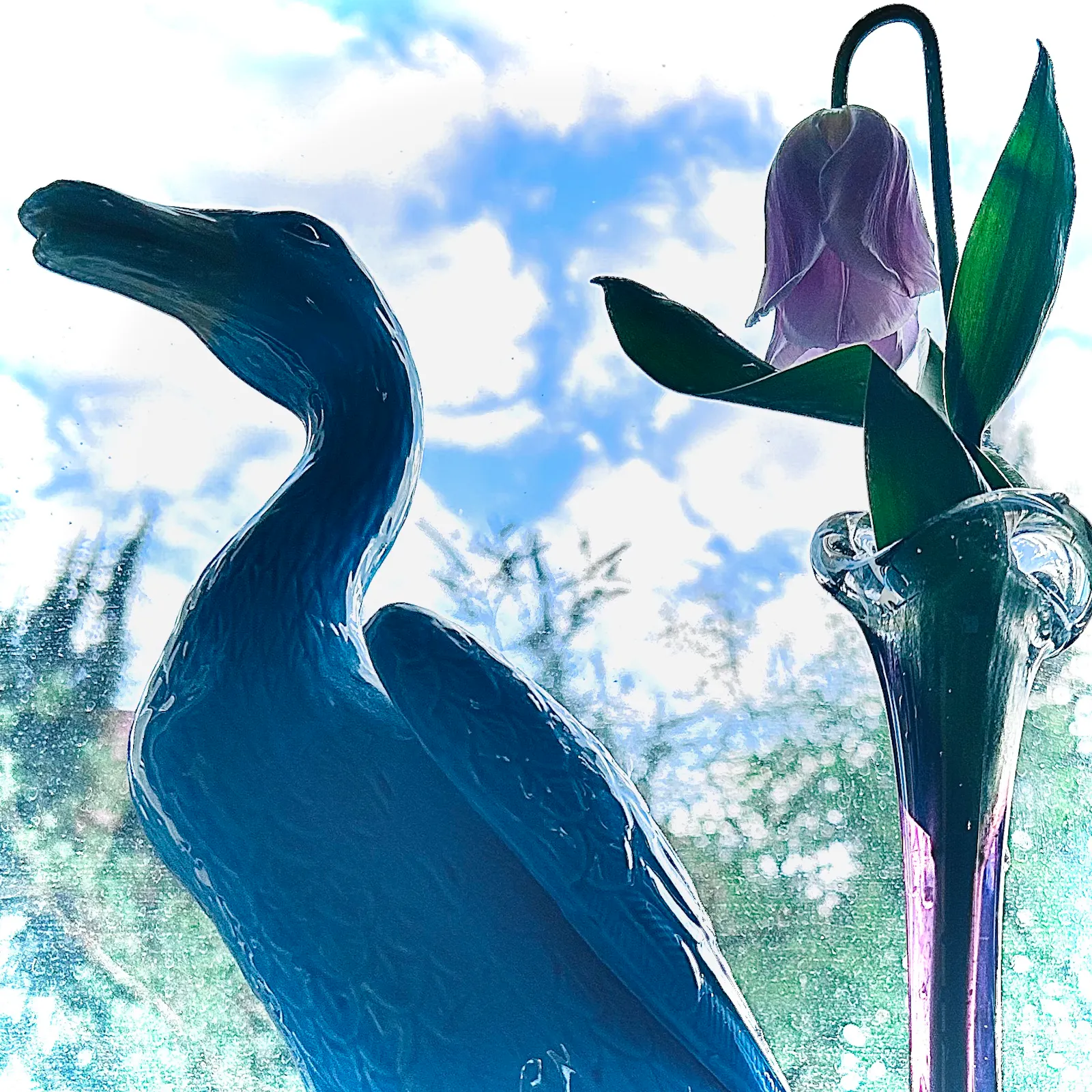 Türkisblaue Keramikente und rosa Tulpe in lila Muranovase