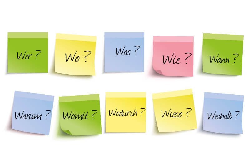 post-its in verschiedenen Farben mit W - Fragen auf weißem Hintergrund