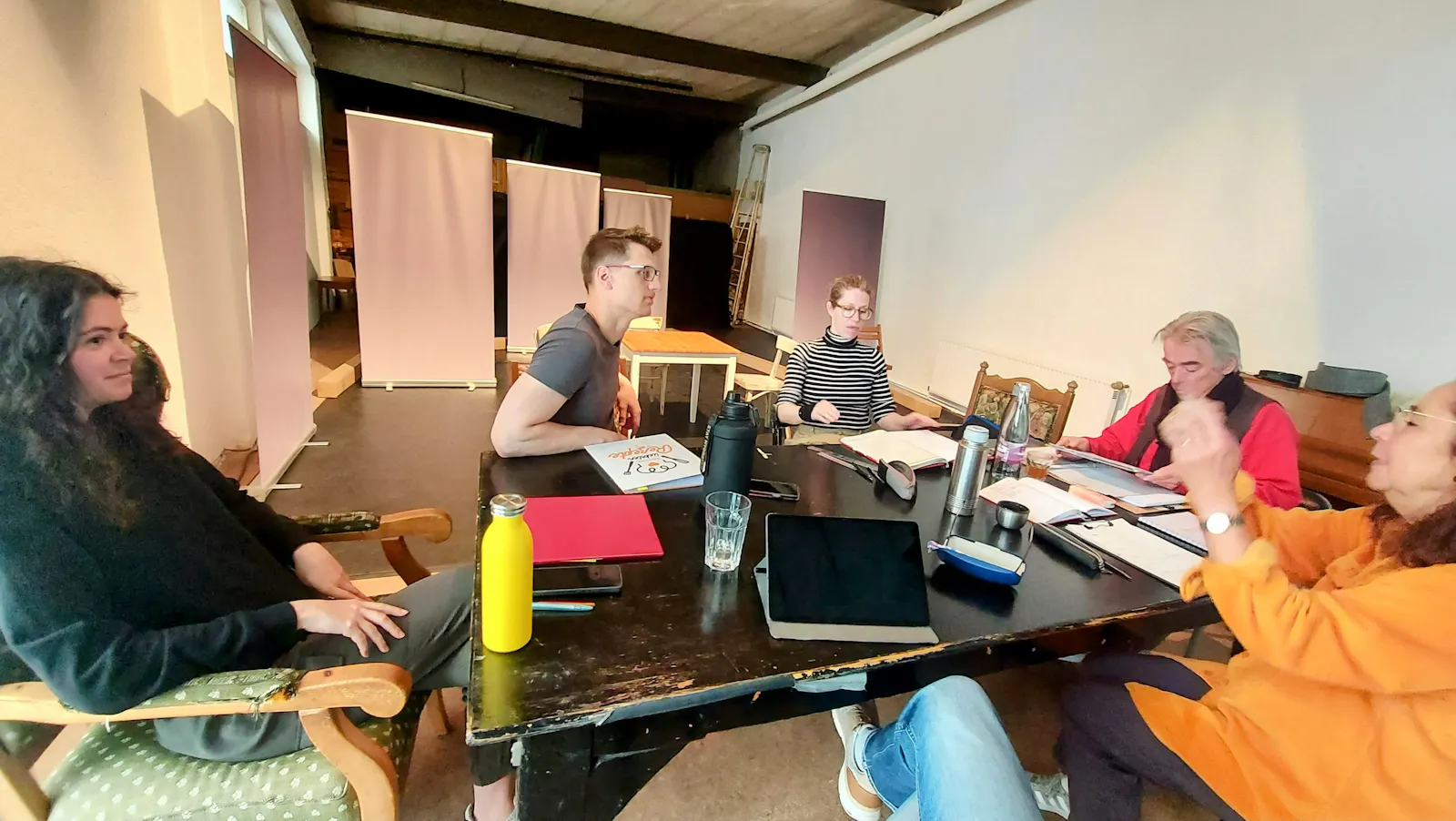 Das Ensemble bei der ersten Konzeptionsprobe um einen Tisch herum sitzend.