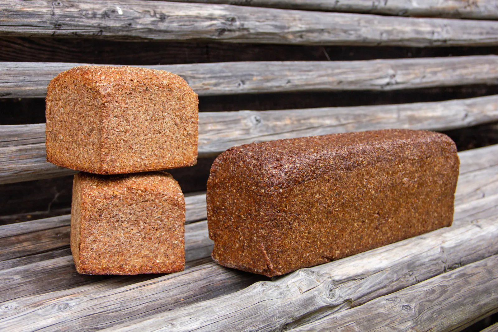 Echter Pumpernickel nach überlieferter Tradition mit Brandsauerteig hergestellt (rechts) und das gleiche Brot mit deutlich kürzerer Backzeit als Roggenschrotbrot/Schwarzbrot (links).