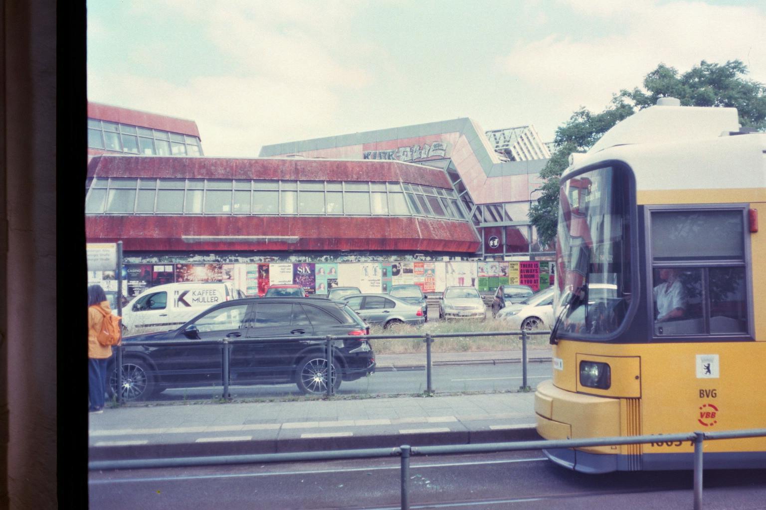 Landsberger Allee, Tramhaltestelle vor dem SEZ am Friedrichshain, eine Tram fährt ein; blass.