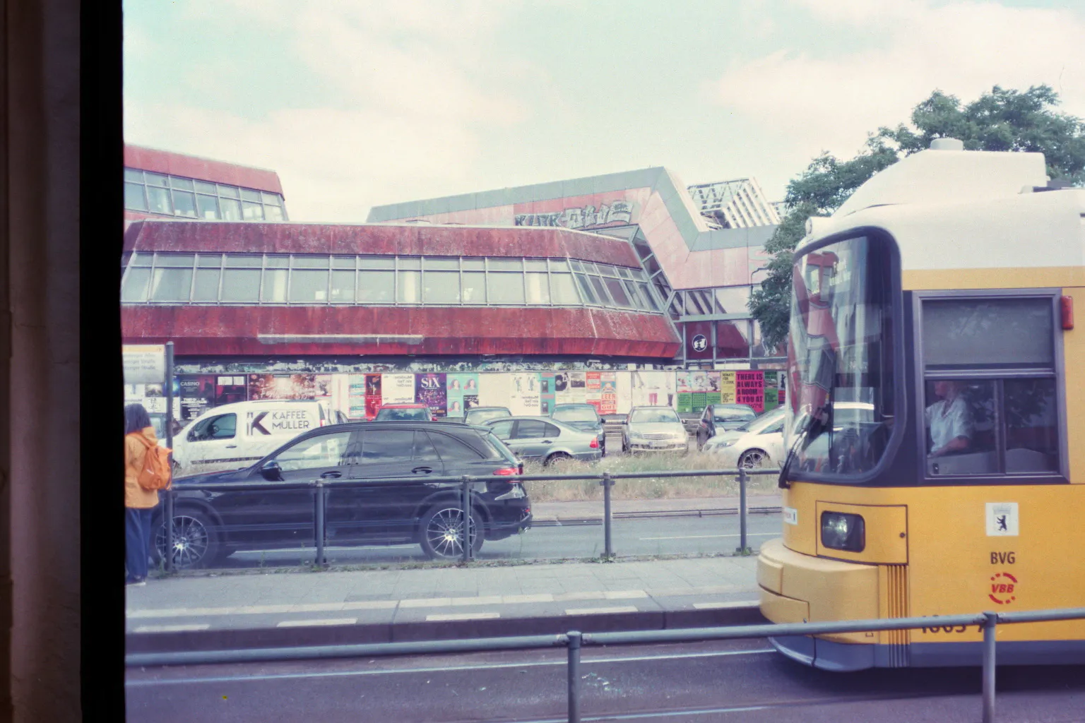 Landsberger Allee, Tramhaltestelle vor dem SEZ am Friedrichshain, eine Tram fährt ein; blass.