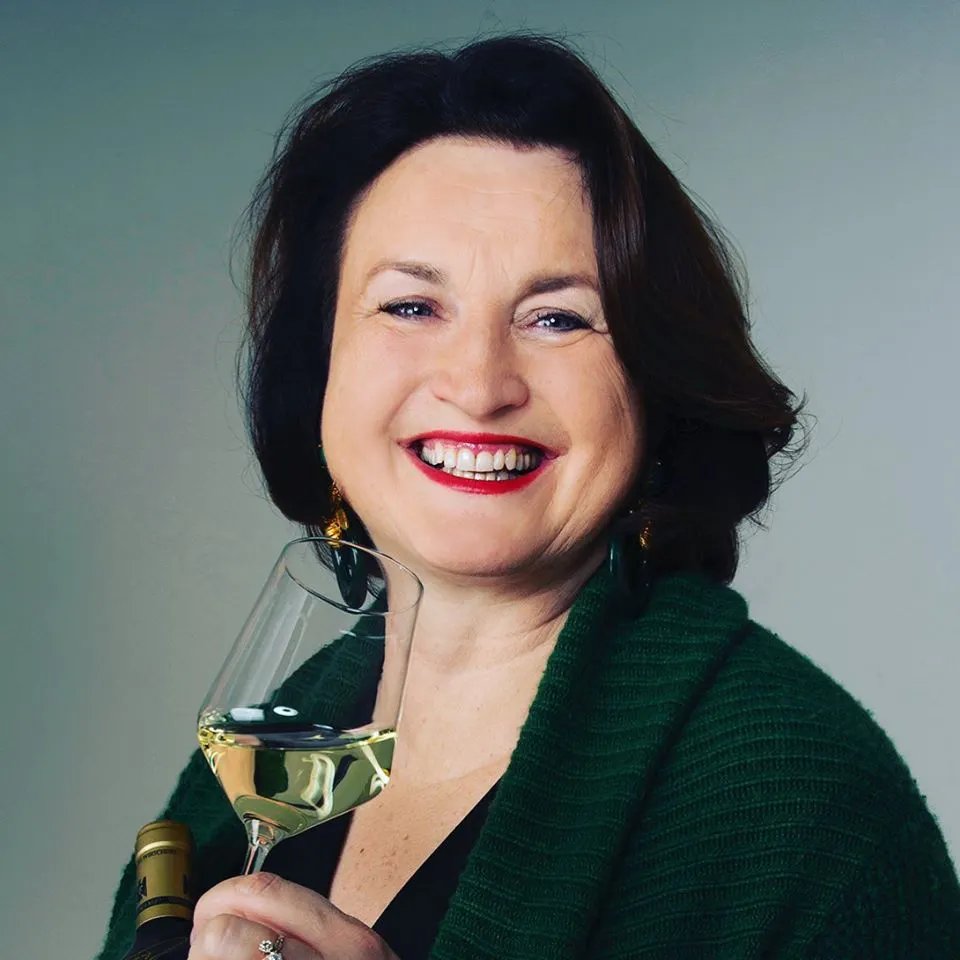 Winzerin Andrea Wirsching hält ein Glas Weißwein in der Hand