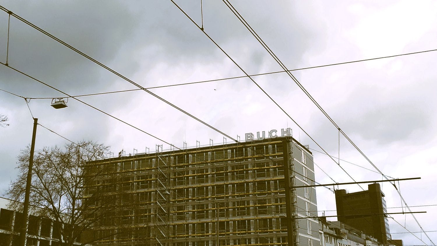 Ein Geschäftshaus vor grauem Himmel. Auf dem Dach des Hauses ist das Wort "Buch" angebracht.