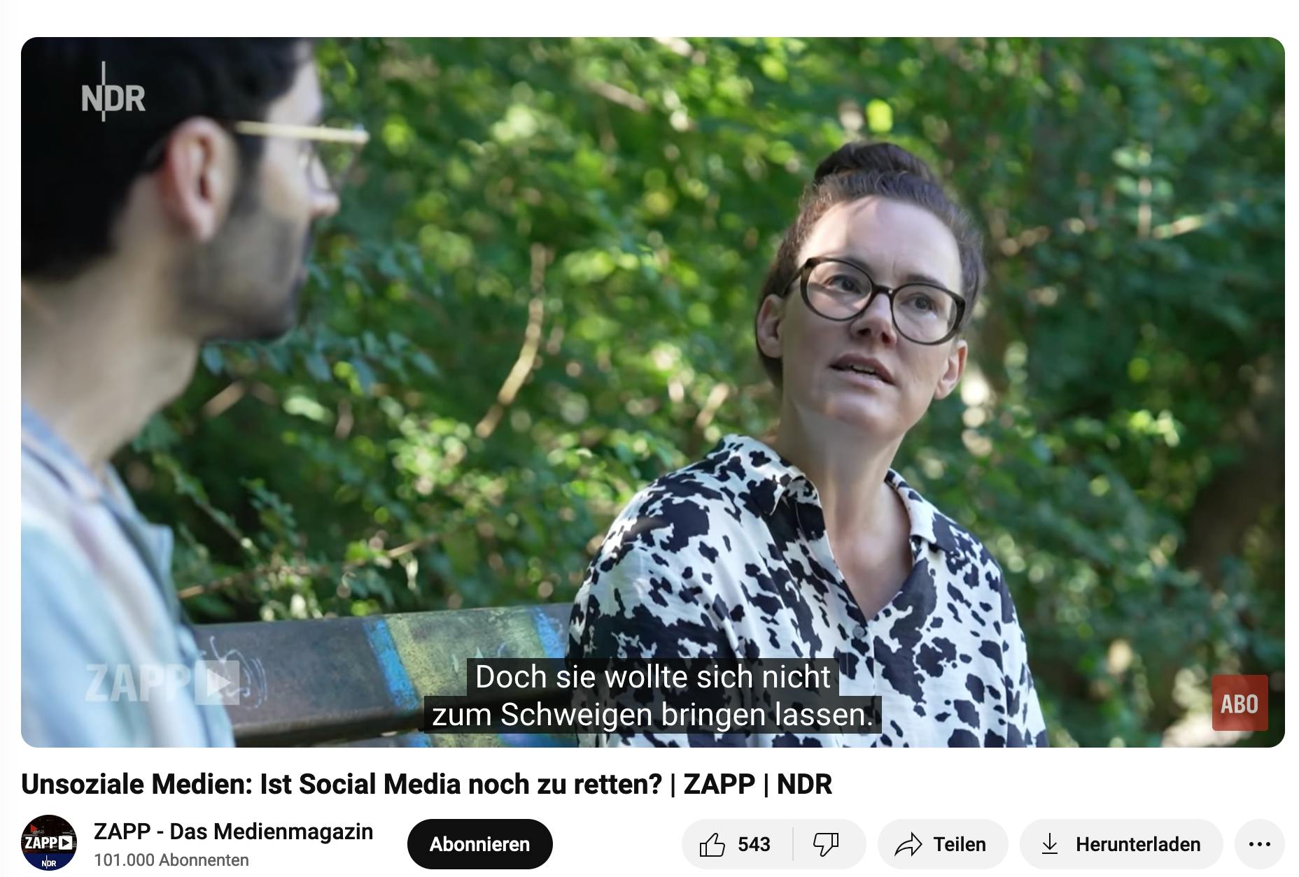 Screenshot aus der Sendung. Unsoziale Medien - ist Social Media noch zu retten. Ich sitze mit dem Redakteur auf einer Bank in einem Park.