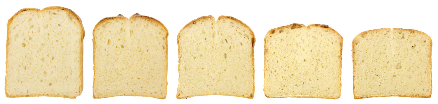 Eine Abfolge von Versuchsbroten (Kastenweißbrot) im Anschnitt.