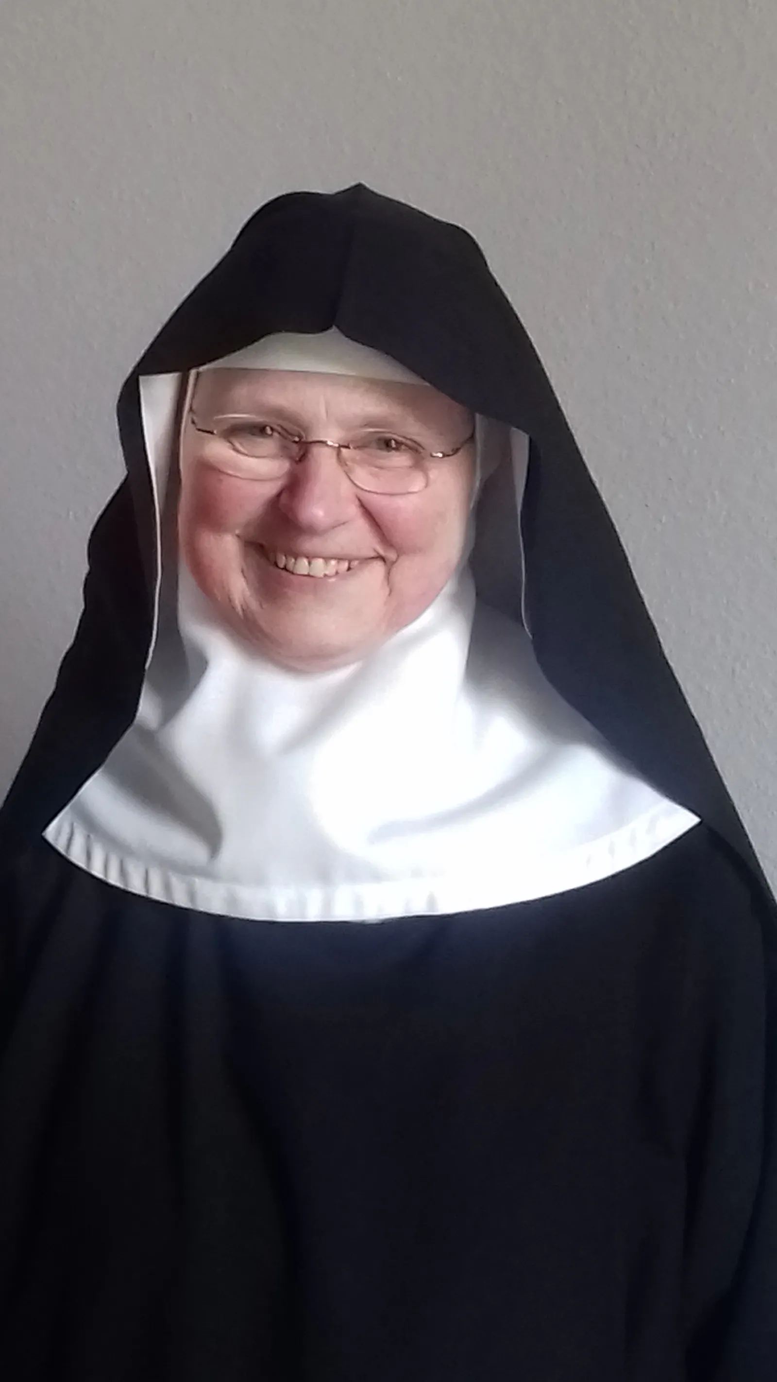 Eine Nonne mit Brille und schwarzem Habit.