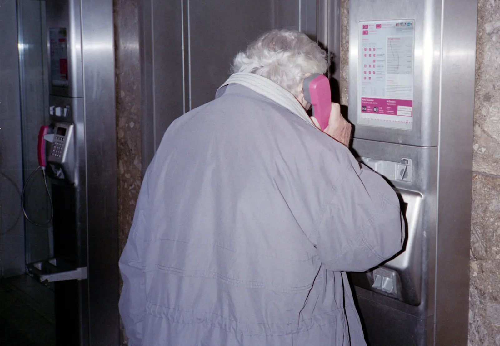 Ein Mensch, der an einer Telefonzelle telefoniert