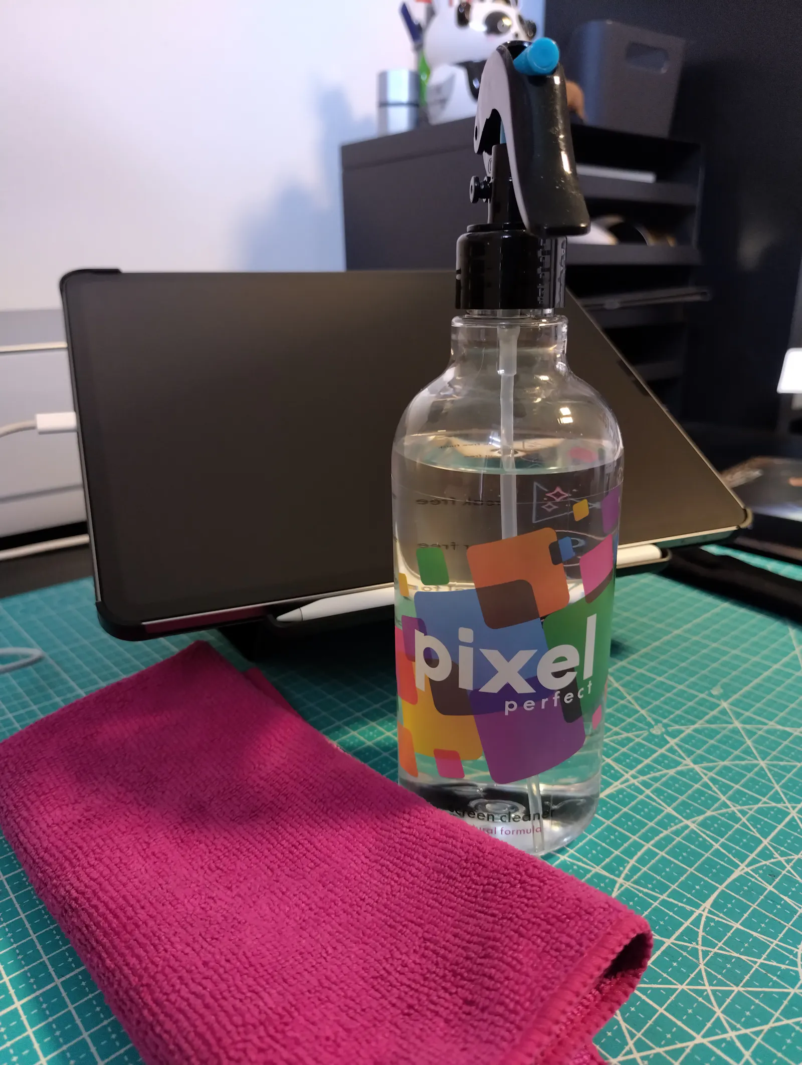 Screen Cleaner von Pixel Perfect vor dem iPad und neben einem pinken Mikrofasertuch