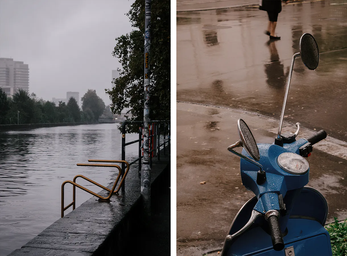 Fluss mit goldener Leiter ins Wasser, dahinter die Stadt im Nebel. Vespa im Regen.