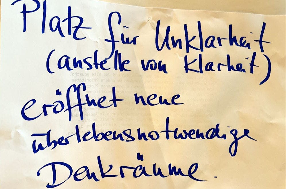 Ein Plakat auf dem steht: "Platz für Unklarheit (anstelle von Klarheit) eröffnet überlebensnotwendige Denkräume.