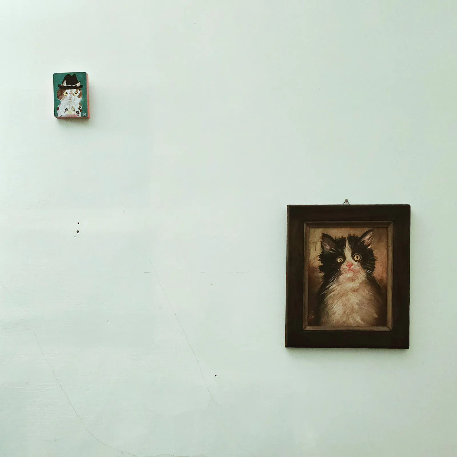 Zwei Katzengemälde an einer Wand