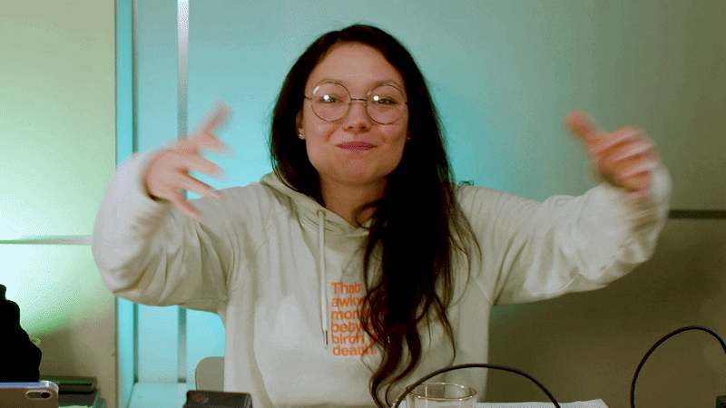 Eine Gif-Datei: Rubi gestikuliert wild in die Kamera und breitet ihre beiden Arme aus, um Farina einzuladen, ihrem Dark Romance Buchclub beizutreten.