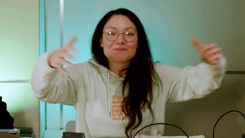 Eine Gif-Datei: Rubi gestikuliert wild in die Kamera und breitet ihre beiden Arme aus, um Farina einzuladen, ihrem Dark Romance Buchclub beizutreten.