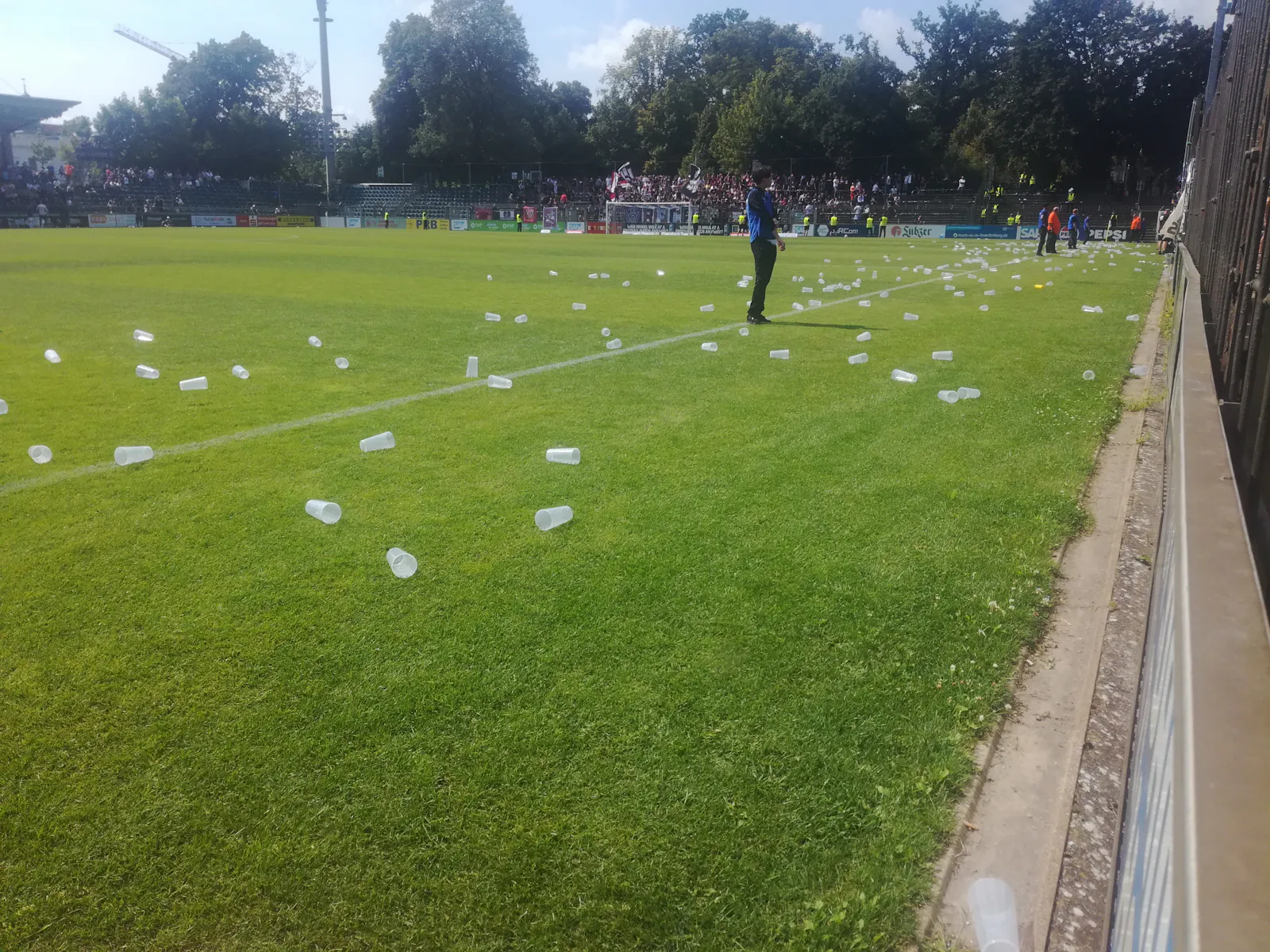Babelsberg 03 gegen BFC Dynamo. Blick die Gegengerade entlang, auf dem Rasen zahlreiche Pfandbecher.