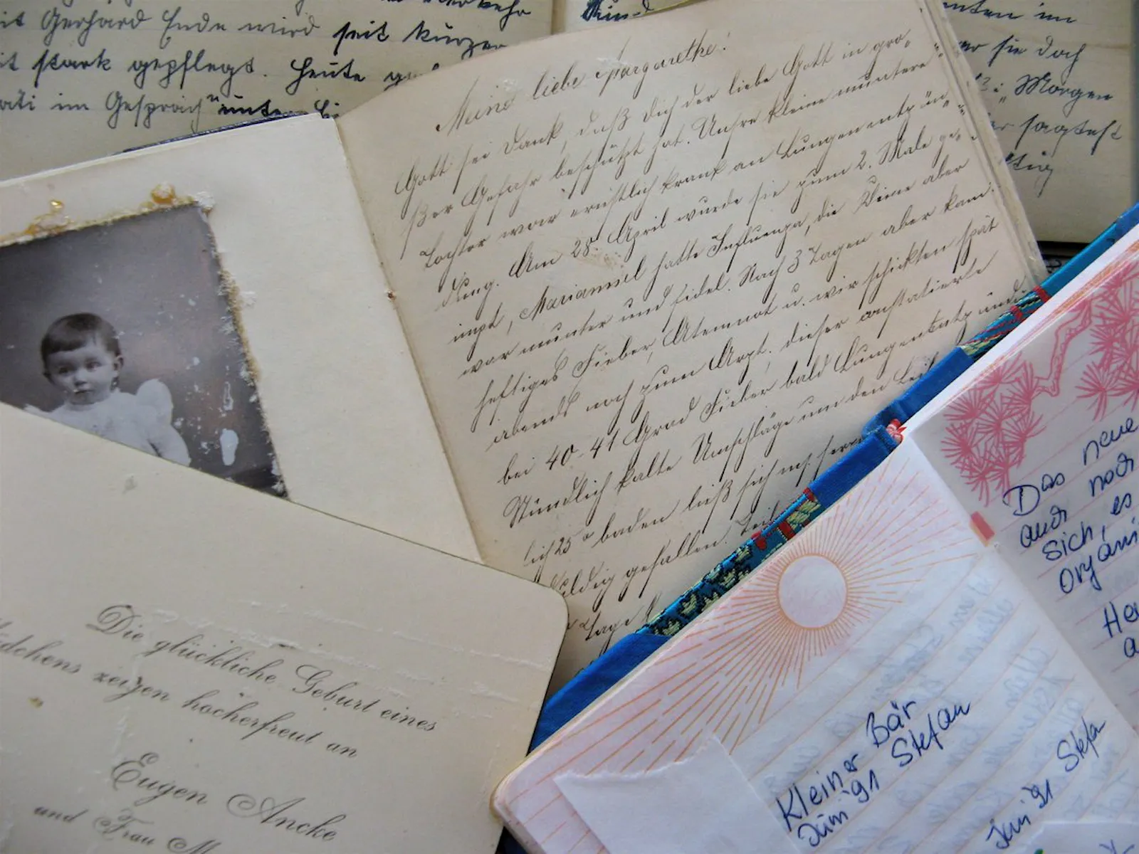 Foto mehrerer, übereinanderliegender, aufgeschlagener Tagebücher - die unterschiedlichen Handschriften zeigen, dass sehr alte und jüngere dabei sind.