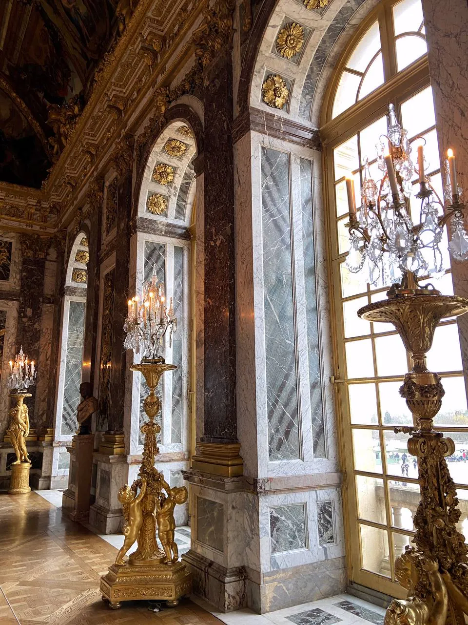 Spiegelsaal im Schloss Versailles, goldene Kronleuchter und Marmor