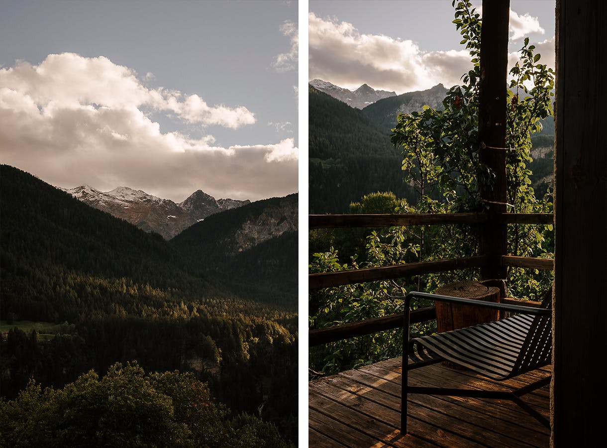 Eine leere Bank auf einer Veranda und der Blick ins Tal und auf die Berge.
