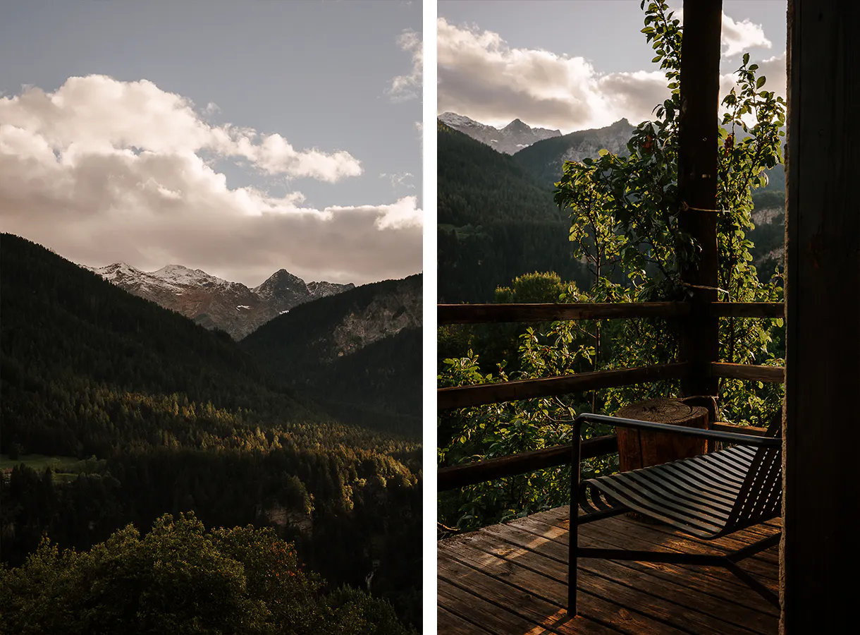 Eine leere Bank auf einer Veranda und der Blick ins Tal und auf die Berge.
