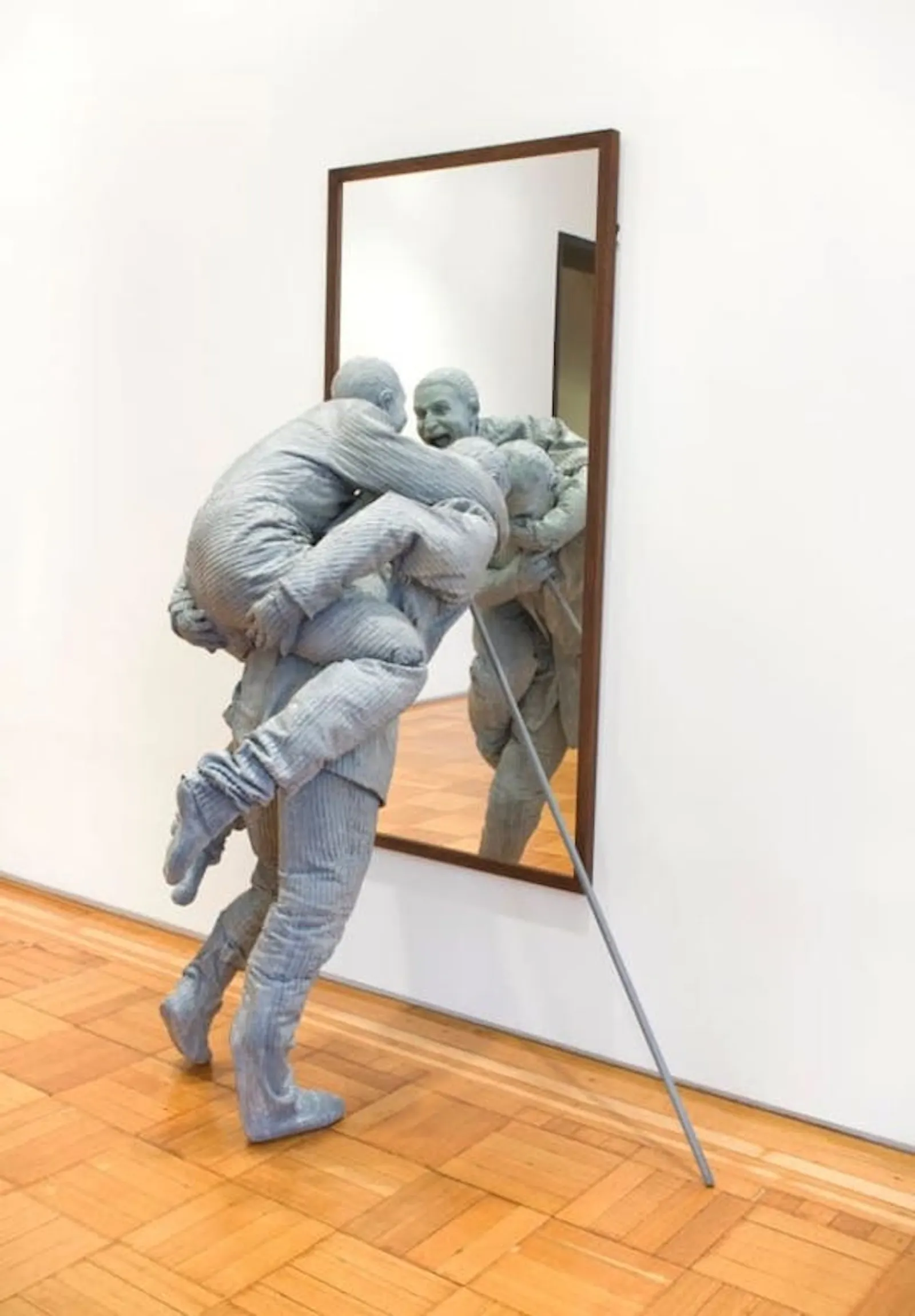 Juan Muñoz hace una escultura de dos hombres, uno al caballito del otro que se miran en un espejo y se ríen.