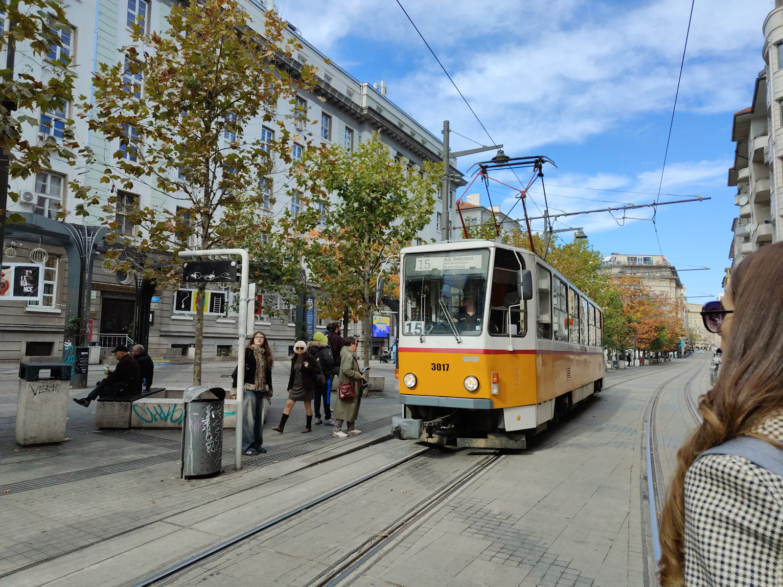 Yellow tram moving along a city street with pedestrians waiting | Георги С. Раковски 147, 1000 Sofia
