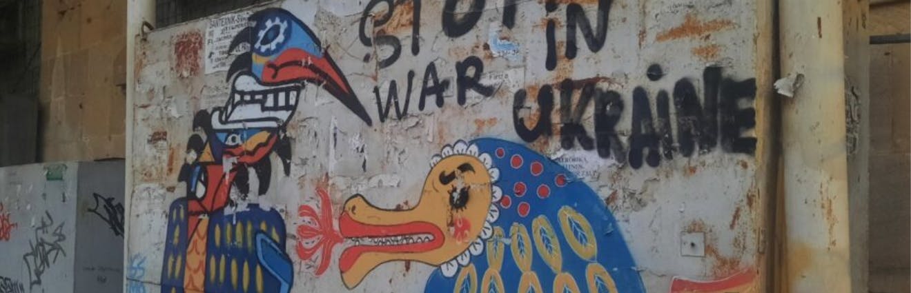 Street art of two birds with text reading "Stop war in Ukraine".