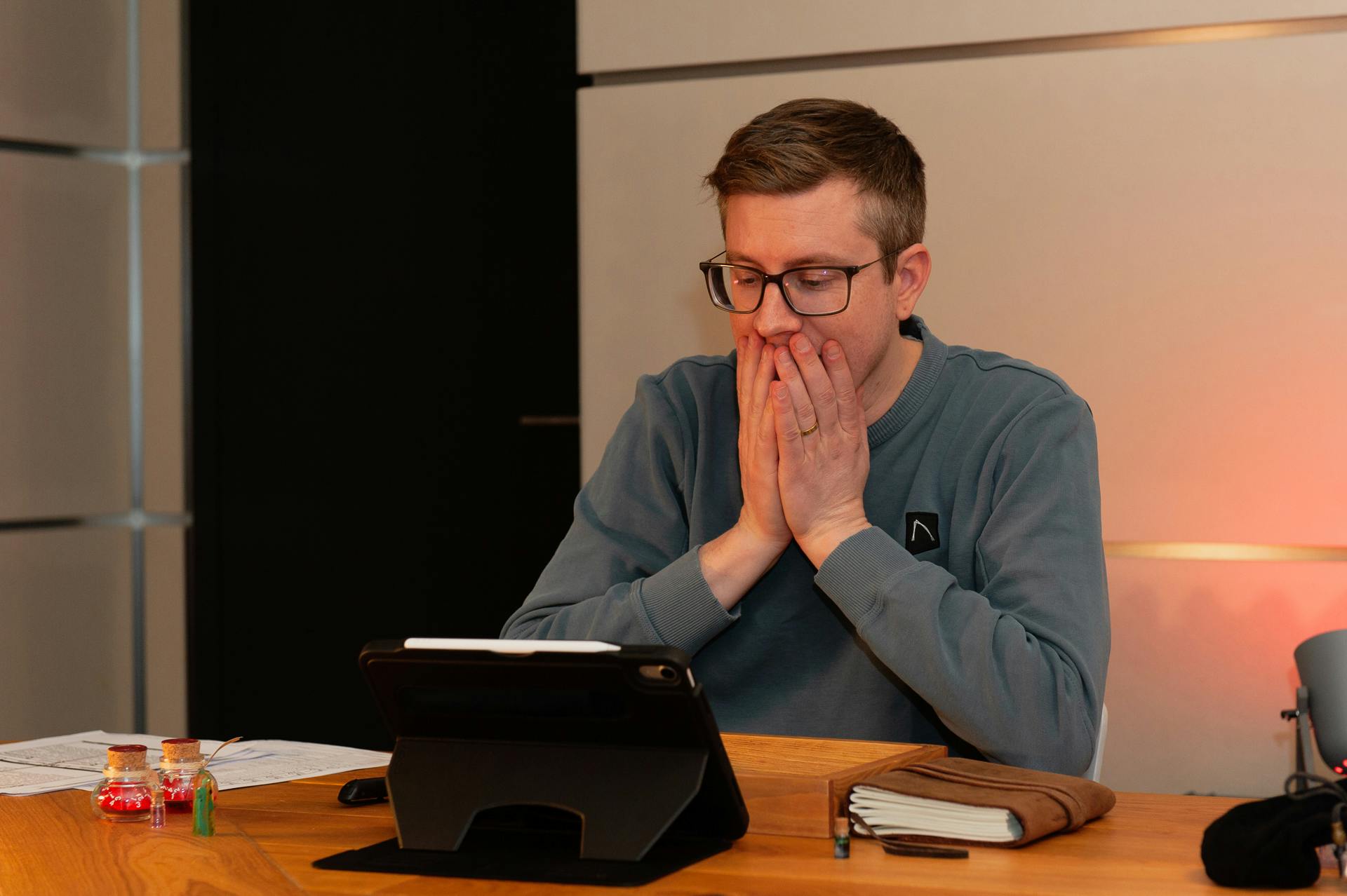Tim guckt auf seinen Spielerbogen und hält dabei erschrocken beide Hände an seinen Mund.