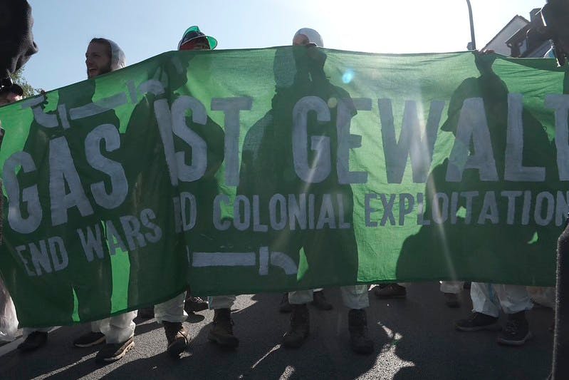 Menschen halten ein grünes Banner mit der Aufschrift "Gas ist Gewalt" im Rahmen der Ende Gelände Massenaktion 2026