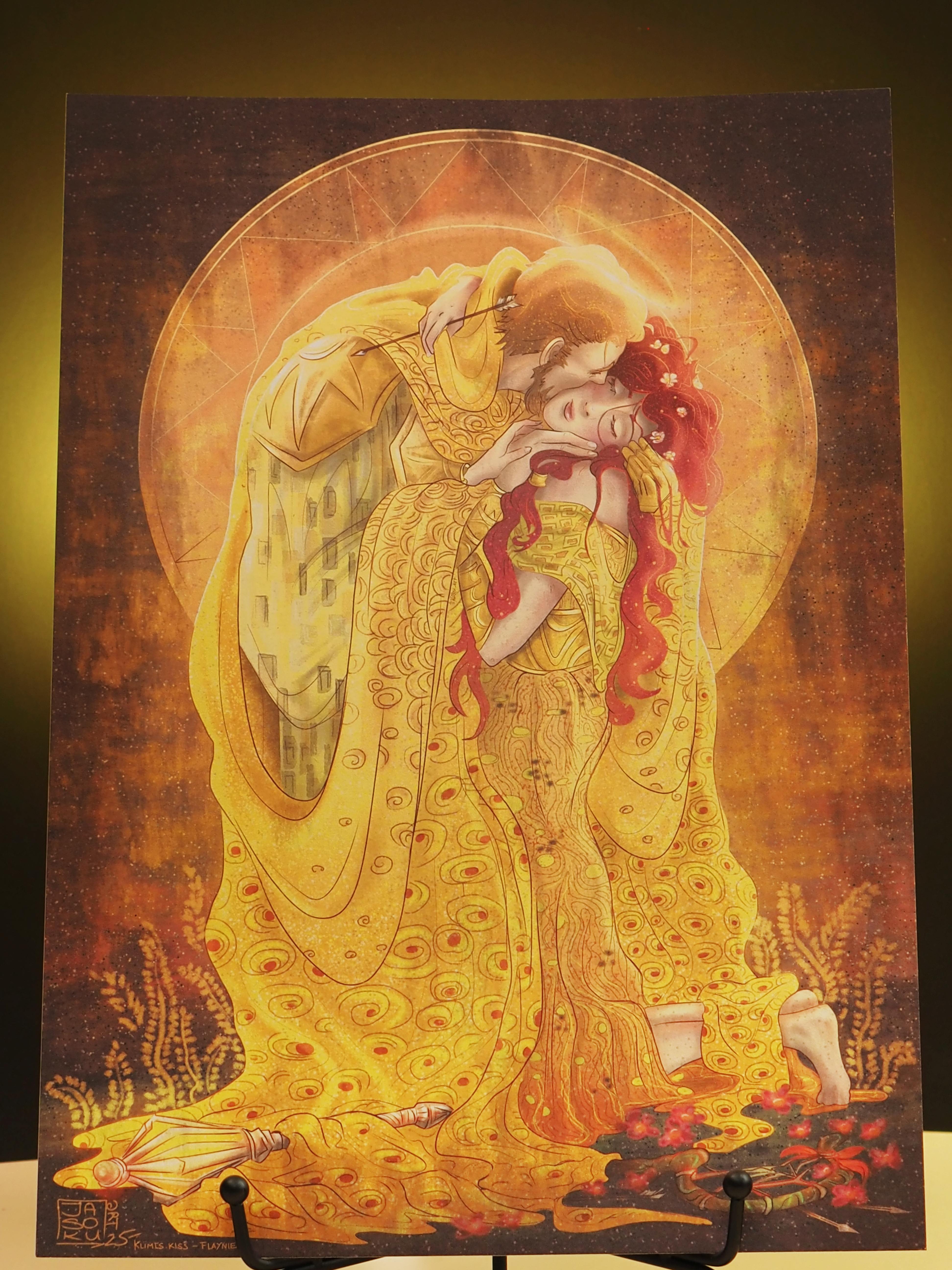 Illustration im Stil von Gustav Klimts „Der Kuss“: Flynt und Elaynie sind in goldene, ornamentreiche Gewänder gehüllt und umarmen sich innig; Flynt küsst Elaynie auf die Wange. Goldene Muster sowie warme Gelb- und Rottöne prägen das Bild.