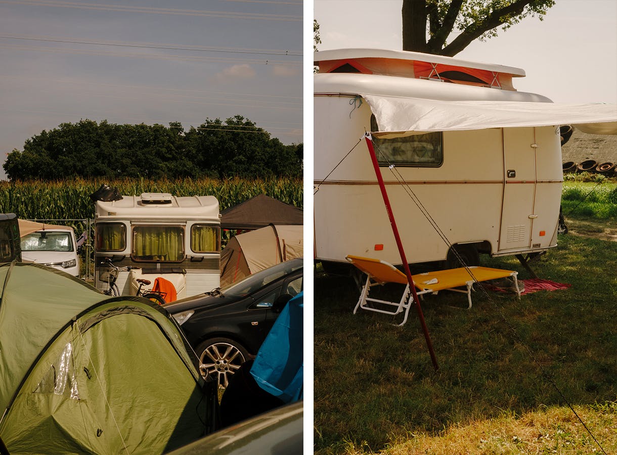 Wohnwagen, Zelte und Autos auf dem Campingplatz des Haldern Pop Festivals, im Hintergrund ein hohes Maisfeld.