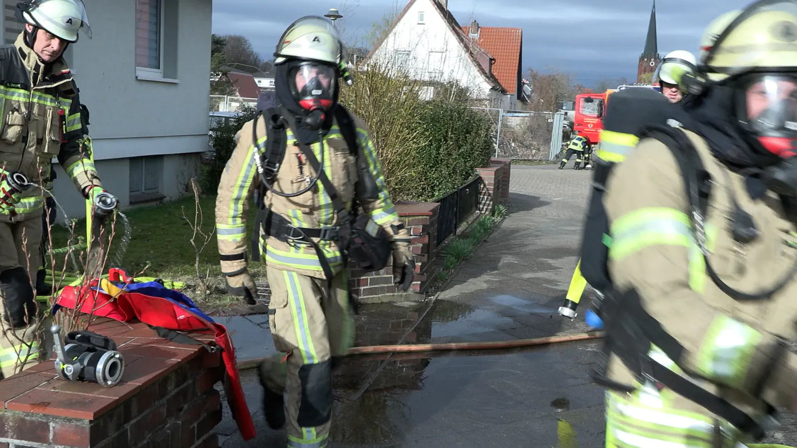 Einsatzkräfte der Feuerwehr vor dem Mehrfamilienhaus