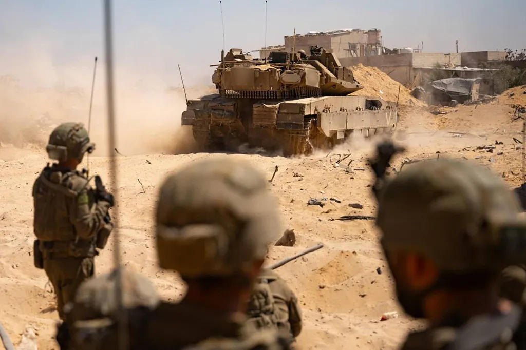 Soldaten der IDF schauen einem Kampfpanzer Merkava nach.