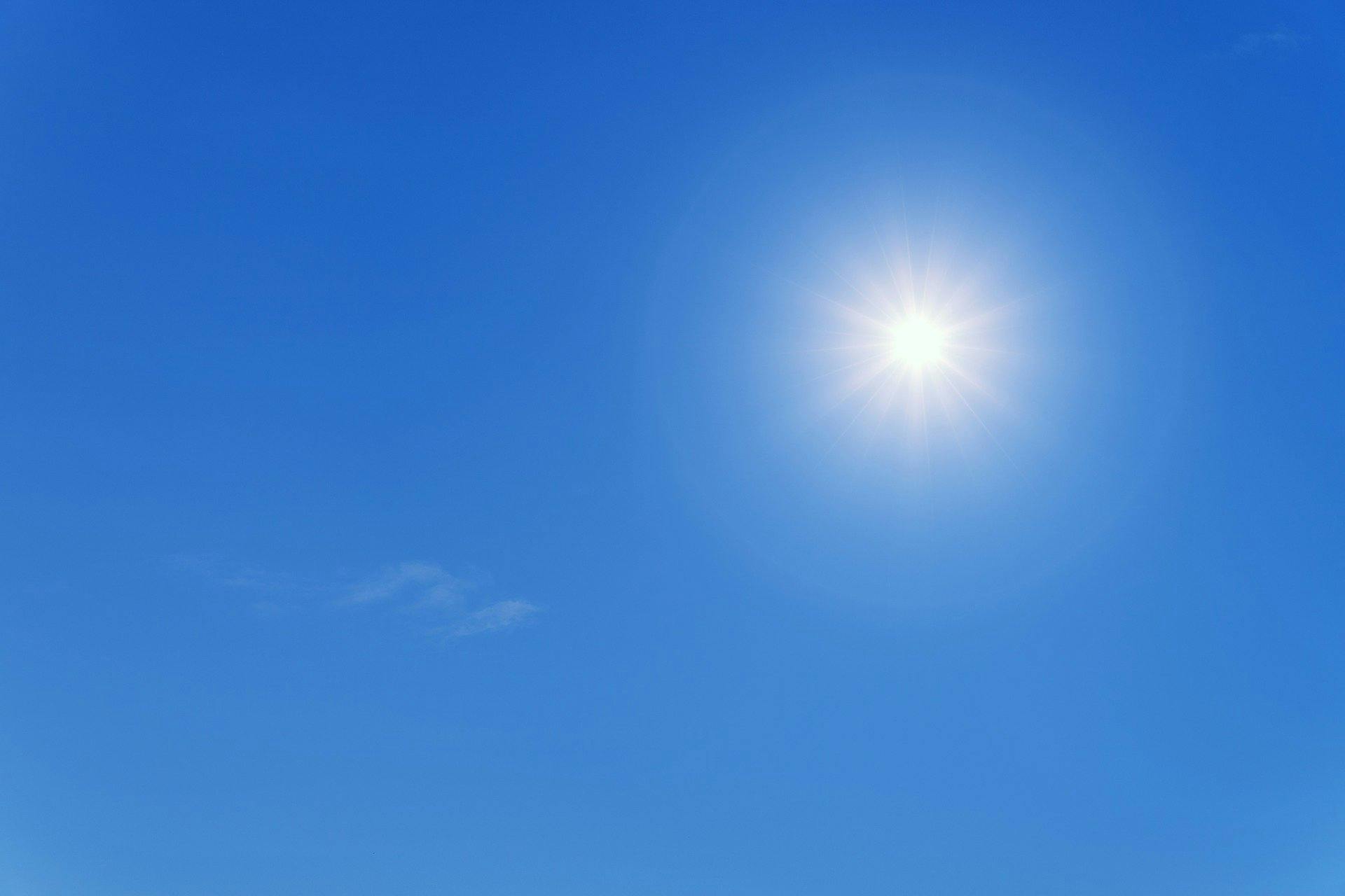 Eine strahlende Sonne an einem wolkenlosen, blauen Himmel.