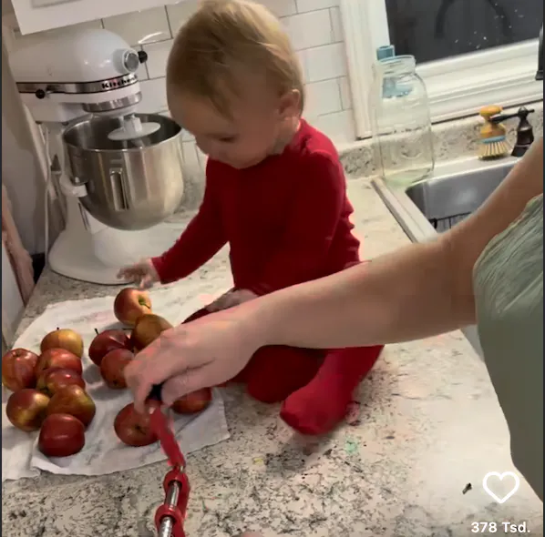 Baby sortiert Äpfel.