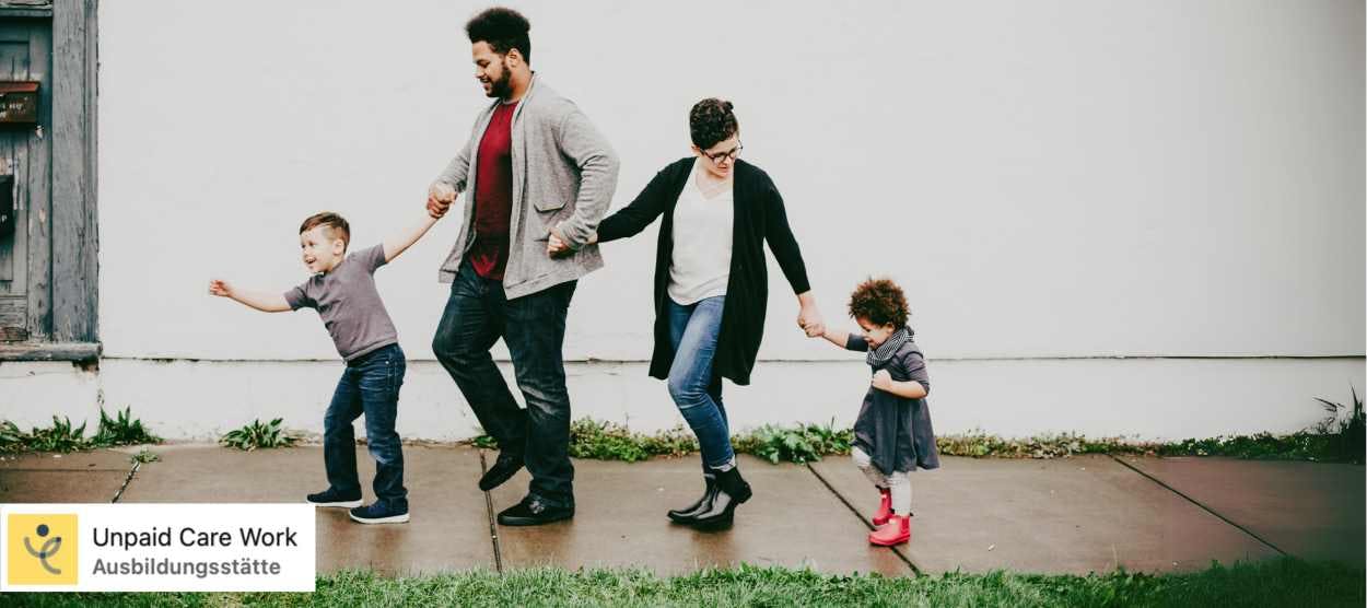 Eine Familie mit kleinem Sohn, Vater, Mutter und kleiner Tochter läuft Hand in Hand entlang eines Gehwegs.