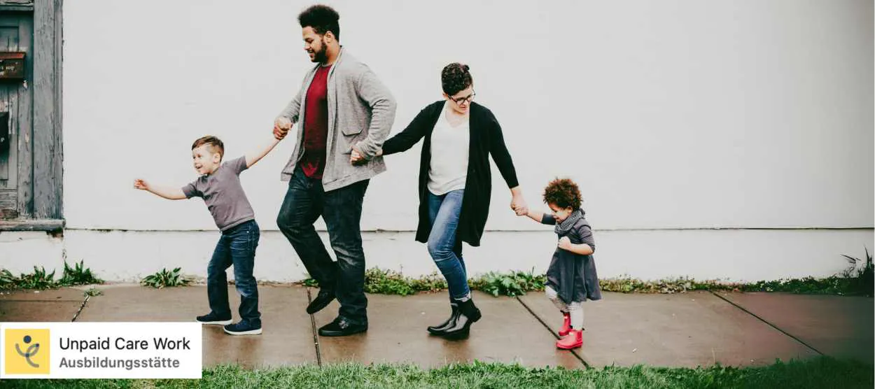 Eine Familie mit kleinem Sohn, Vater, Mutter und kleiner Tochter läuft Hand in Hand entlang eines Gehwegs.