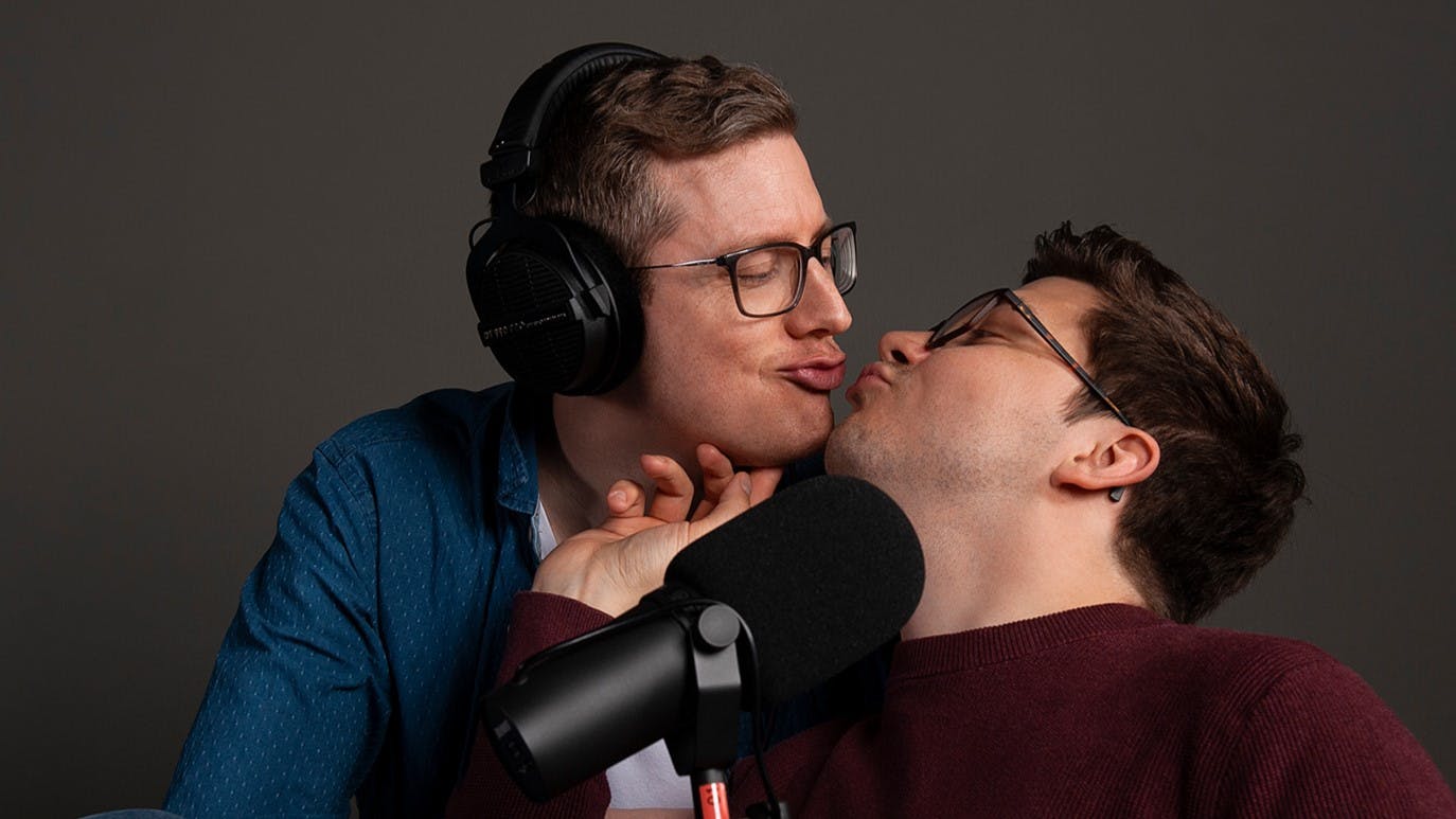 Tim und Patze in Podcast-Montur, kurz vor einem Kuss.