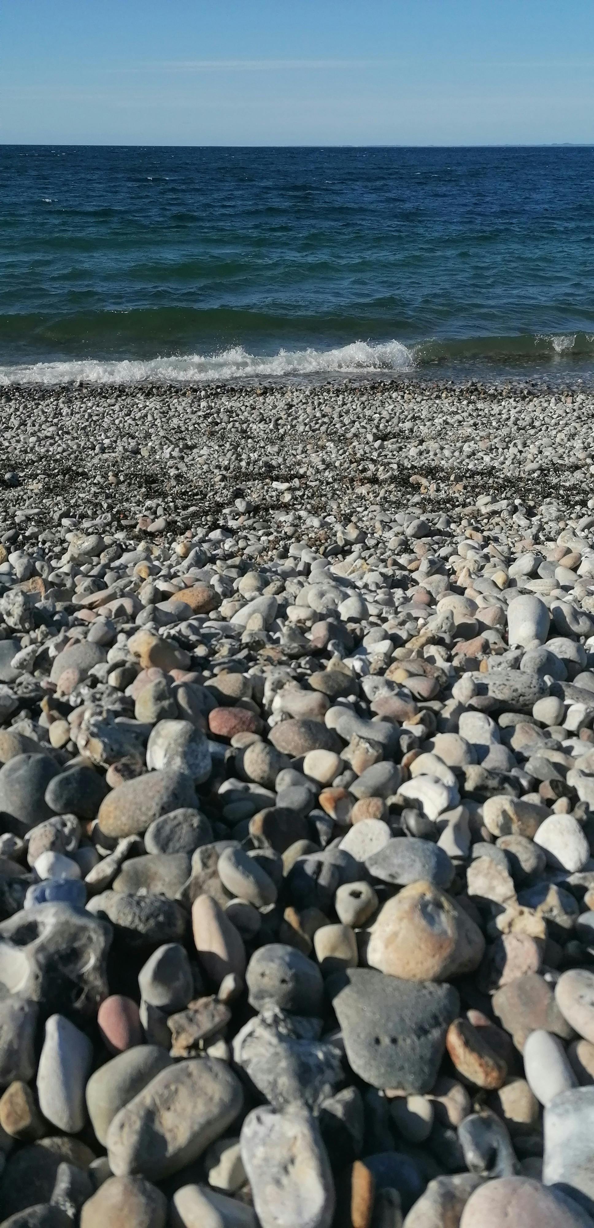 Ein Strand voller Steine und das Meer.