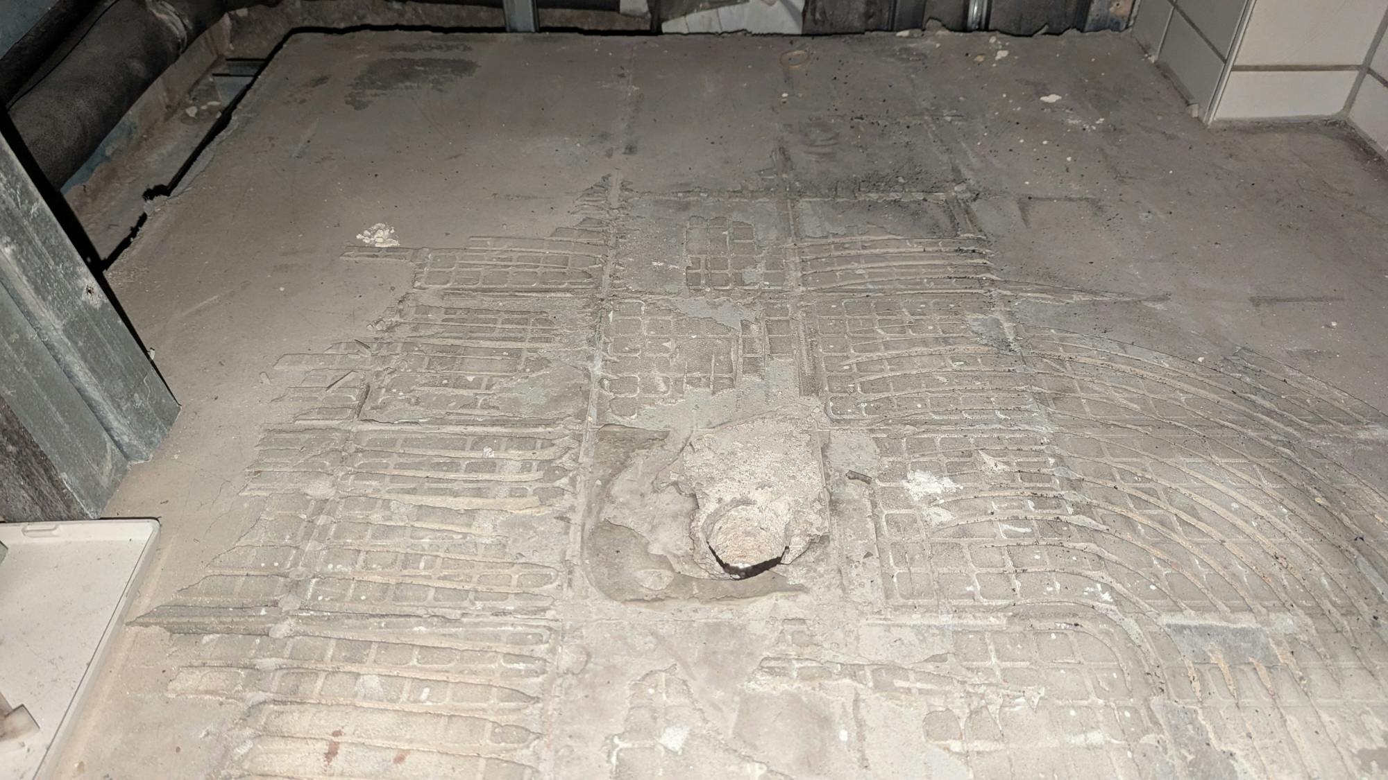 Nackter Beton mit einem Relief aus Spuren des Fliesenklebers.