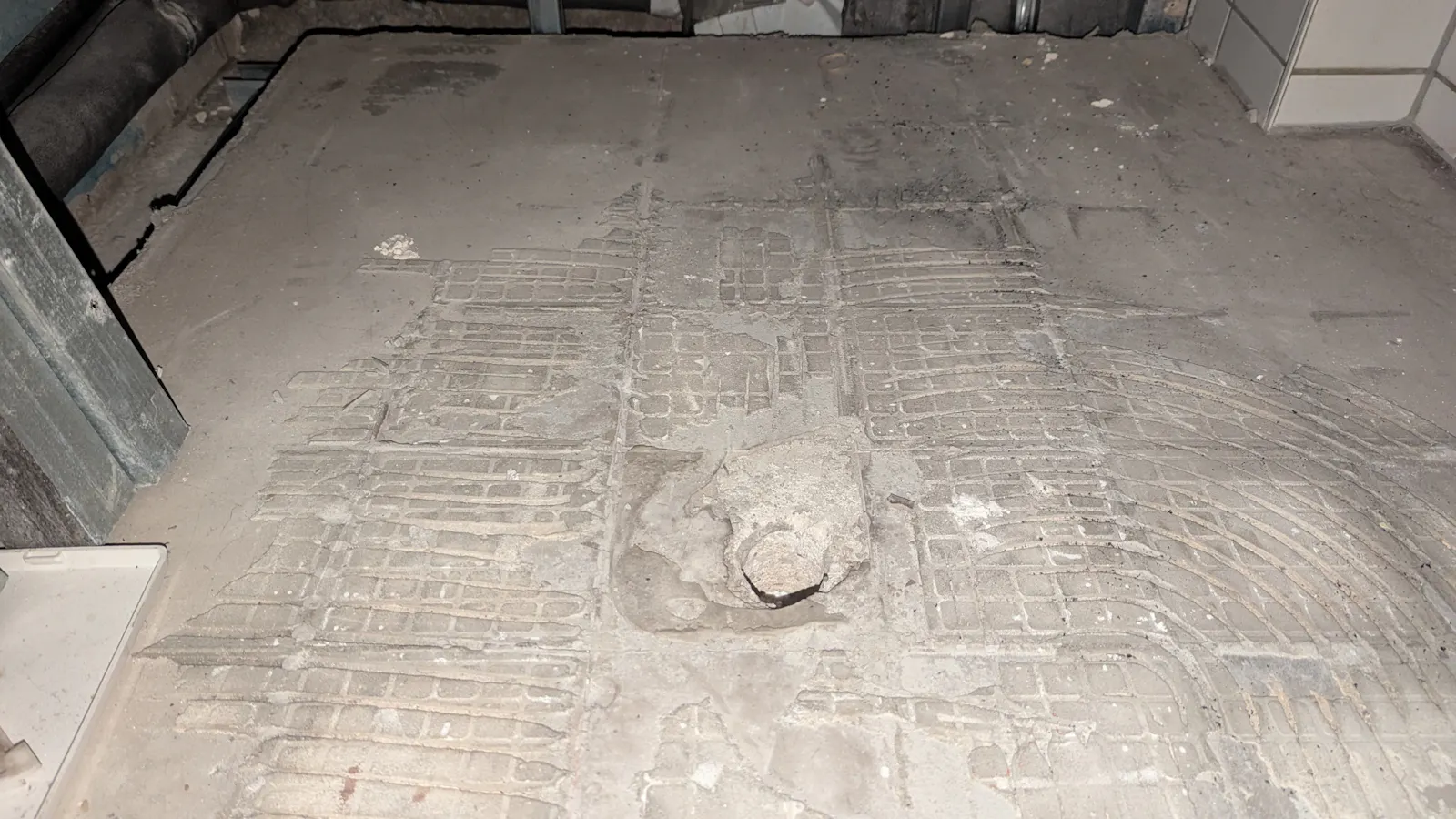 Nackter Beton mit einem Relief aus Spuren des Fliesenklebers.