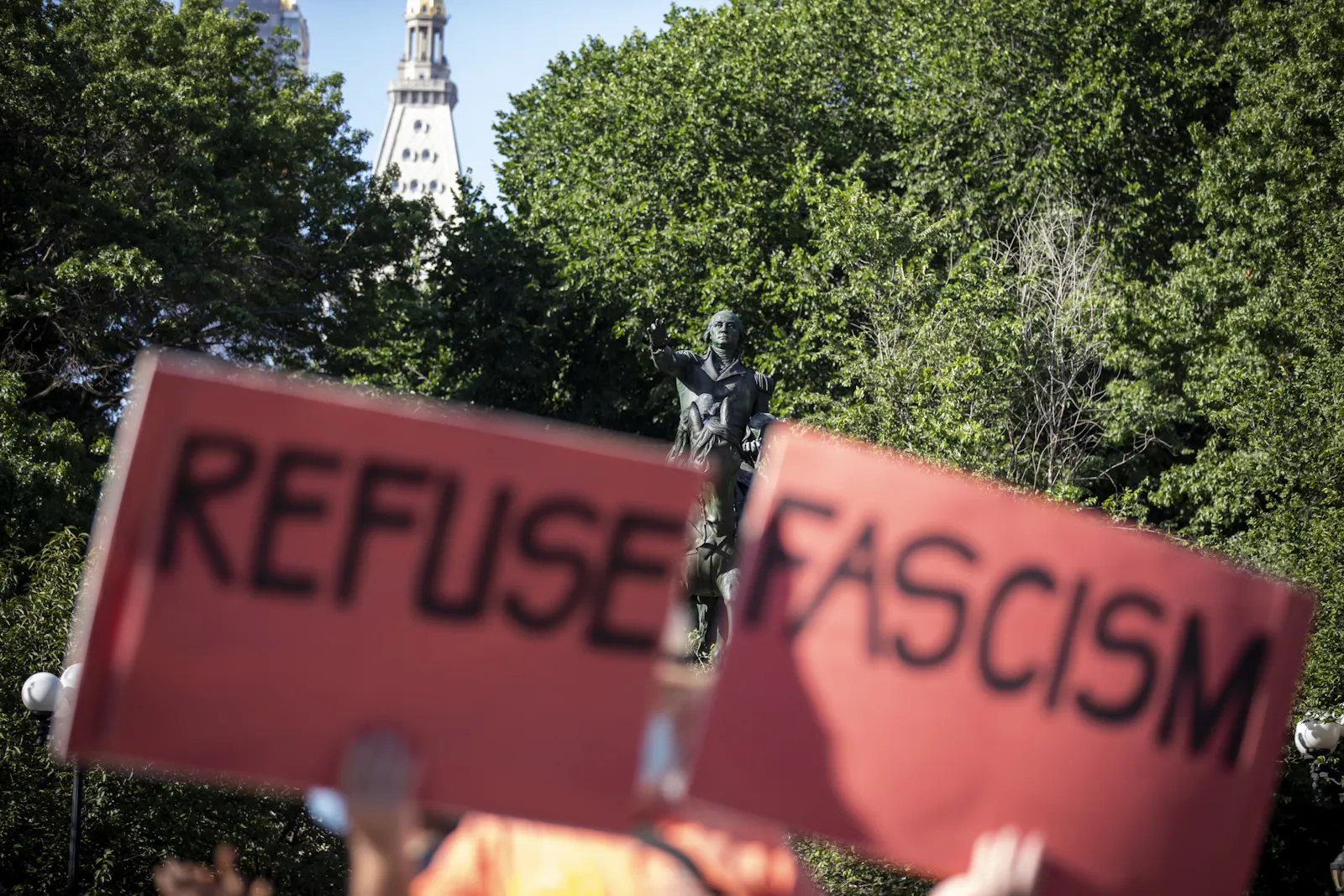 Protestschild auf einer Demo in 2021 in Washington. Eine Person, die nicht genauer zu erkennen ist, hält zwei Schilder hoch: Refuse Fascism