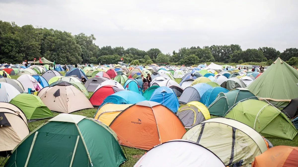 viele bunte Zelte auf einer Wiese, im Hintergrund Bäume