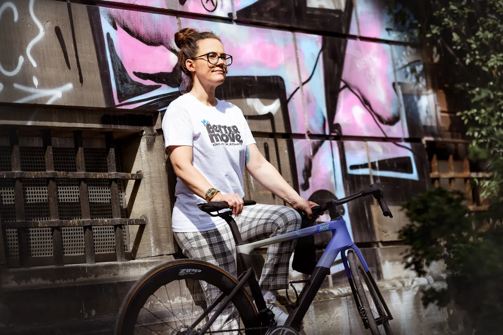Ich trage das Tshirt, lehne an einer Mauer mit Graffitti und halte ein Fahrrad.