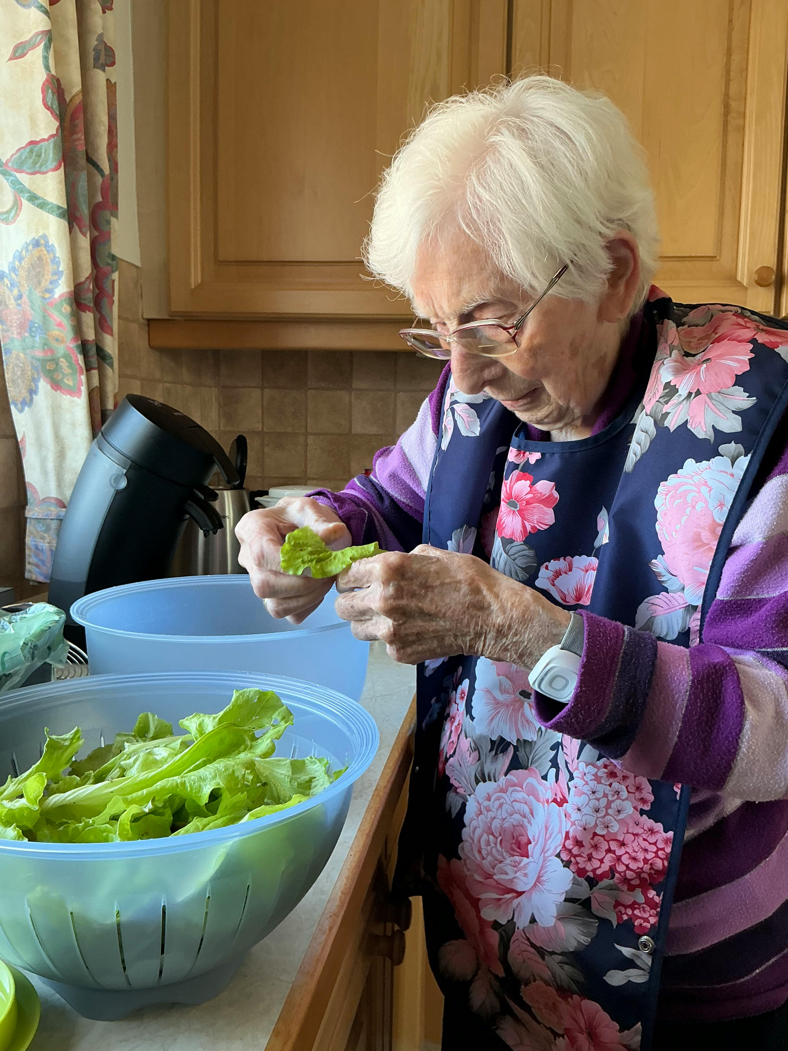 Oma beim Salat wäschen