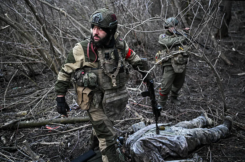Russische Soldaten über einem erschossenen Ukrainer.