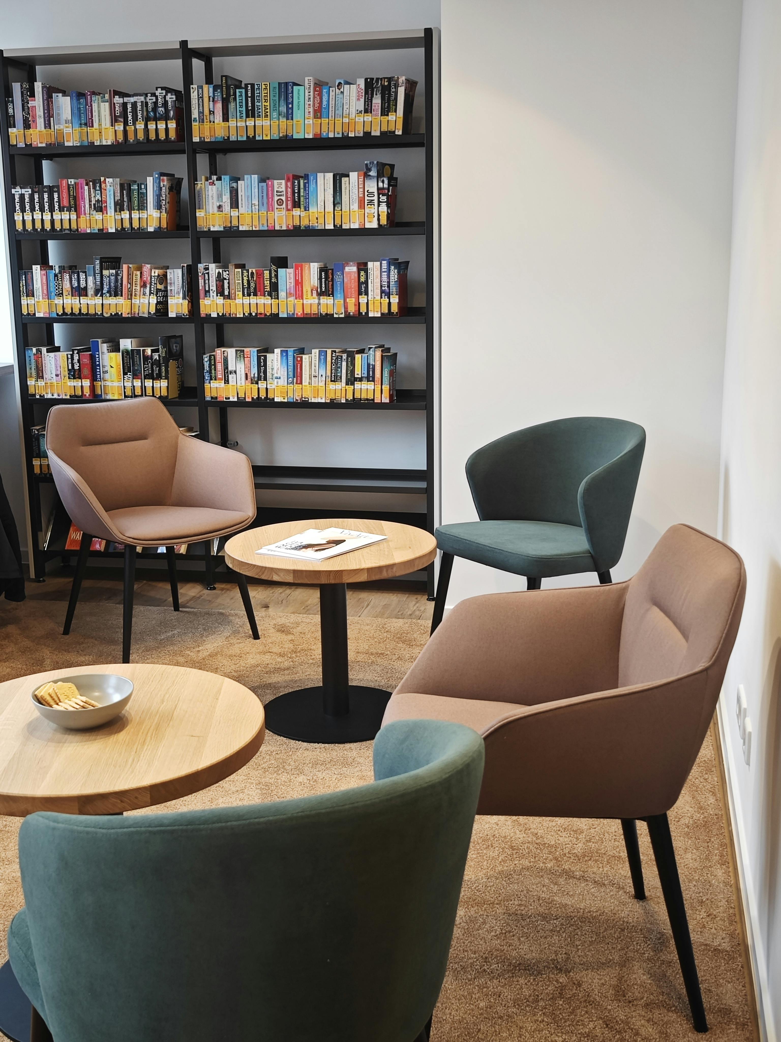 An der Wand steht ein Regal mit Büchern und davor bequeme Stühle im Kulturzentrum Limburg