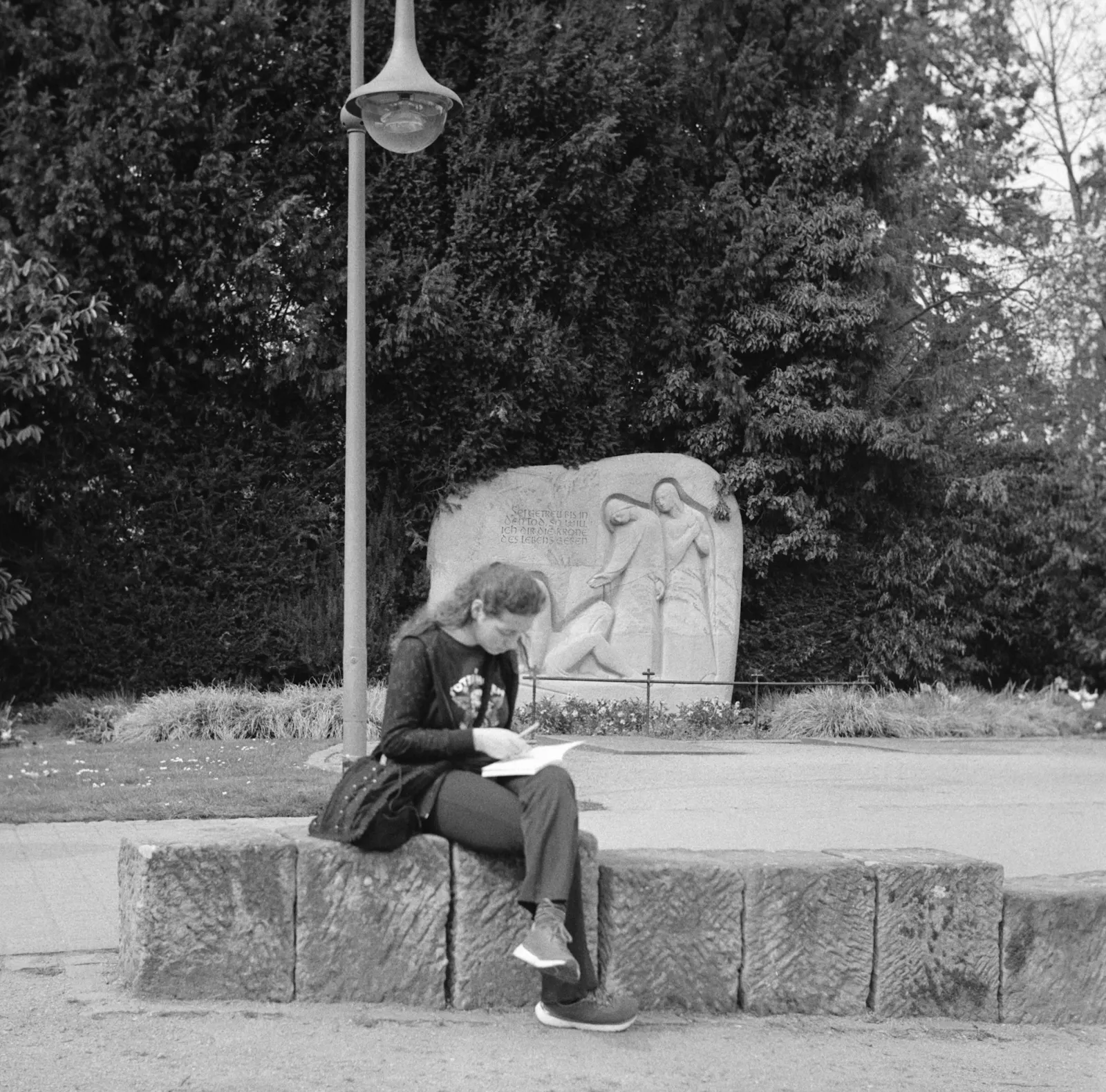 Streetfotografie Bad Dürkheim.
Frau liest auf einem Stein.
